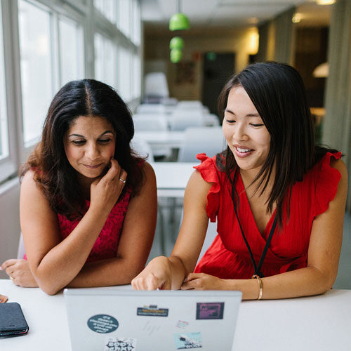 Kaksi naispuolista kollegaa katselee kannettavan tietokoneen näyttöä