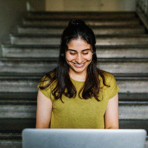 Vrouw kijkt neer op een laptop