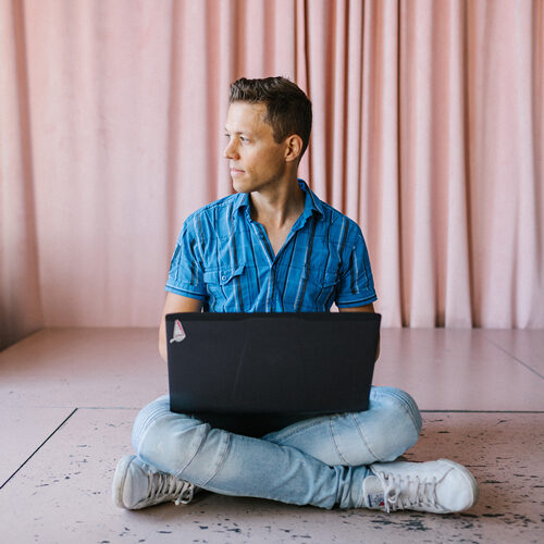 Homem sentado no chão com um laptop