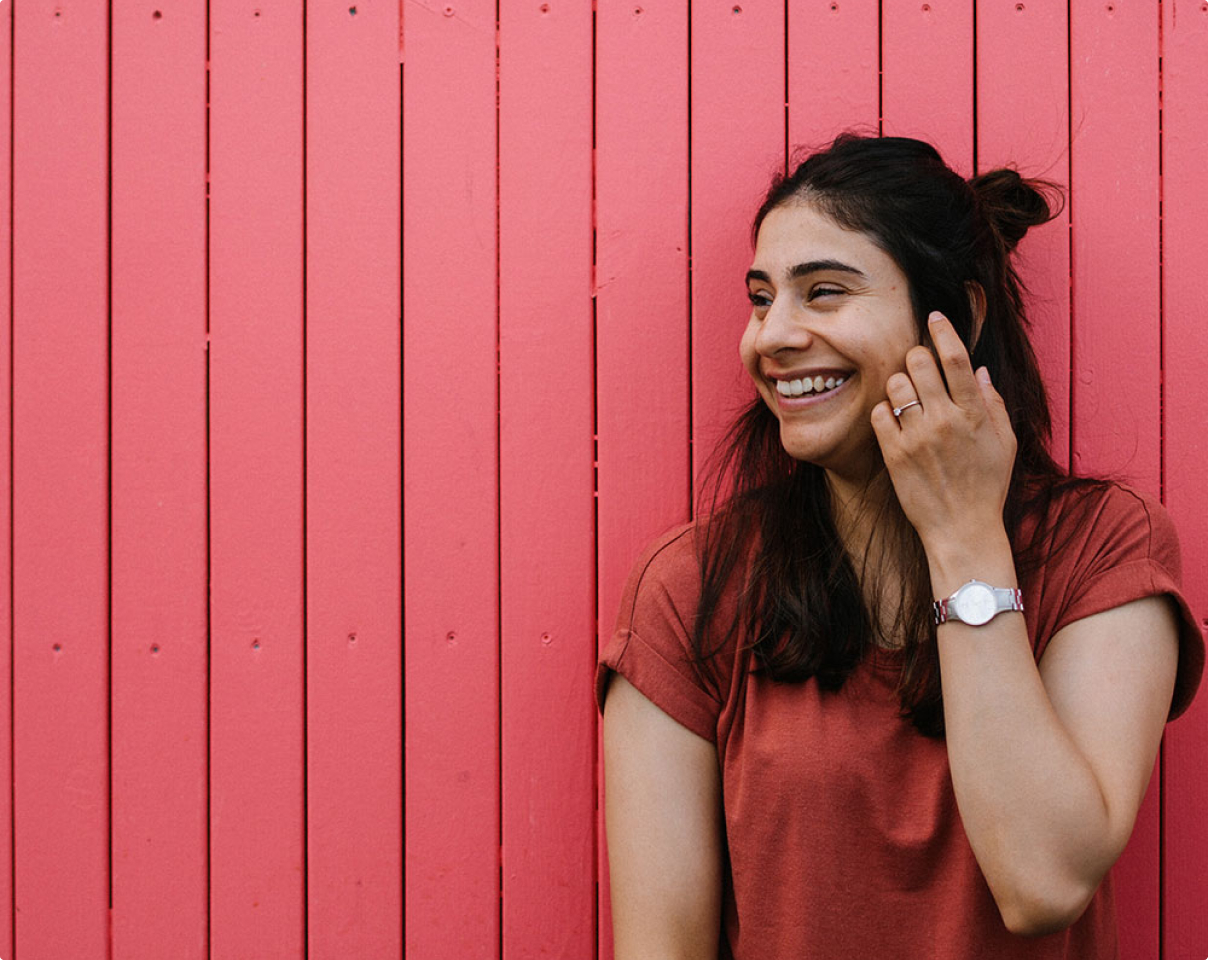 Une jeune femme qui rit et regarde hors caméra